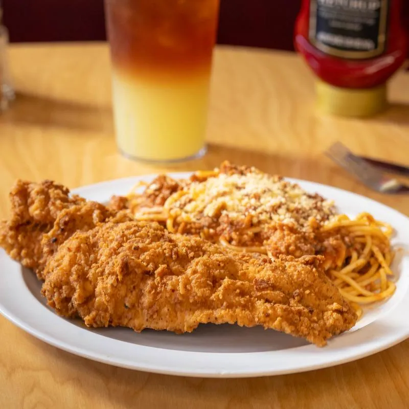 A fried catfish fillet served with spaghetti