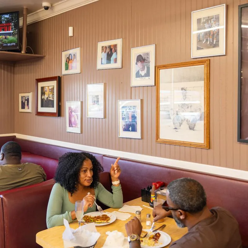 Guests talking over a meal in a red booth